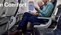 men sitting on an airplane looking at a paper