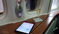 a glass of champagne next to a tablet on a table