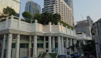 a building with columns and trees in front of it