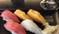 a plate of sushi and a glass of wine