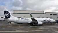 a large white airplane parked in front of a building