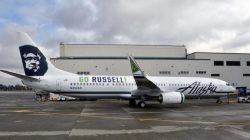 a large white airplane parked in front of a building