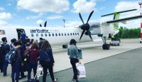 a group of people standing next to a plane