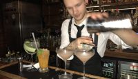 a man pouring a drink into a glass