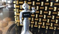 a robot standing in front of a wall of gold bars