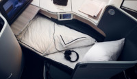 a bed with headphones and a monitor on the side of the seat