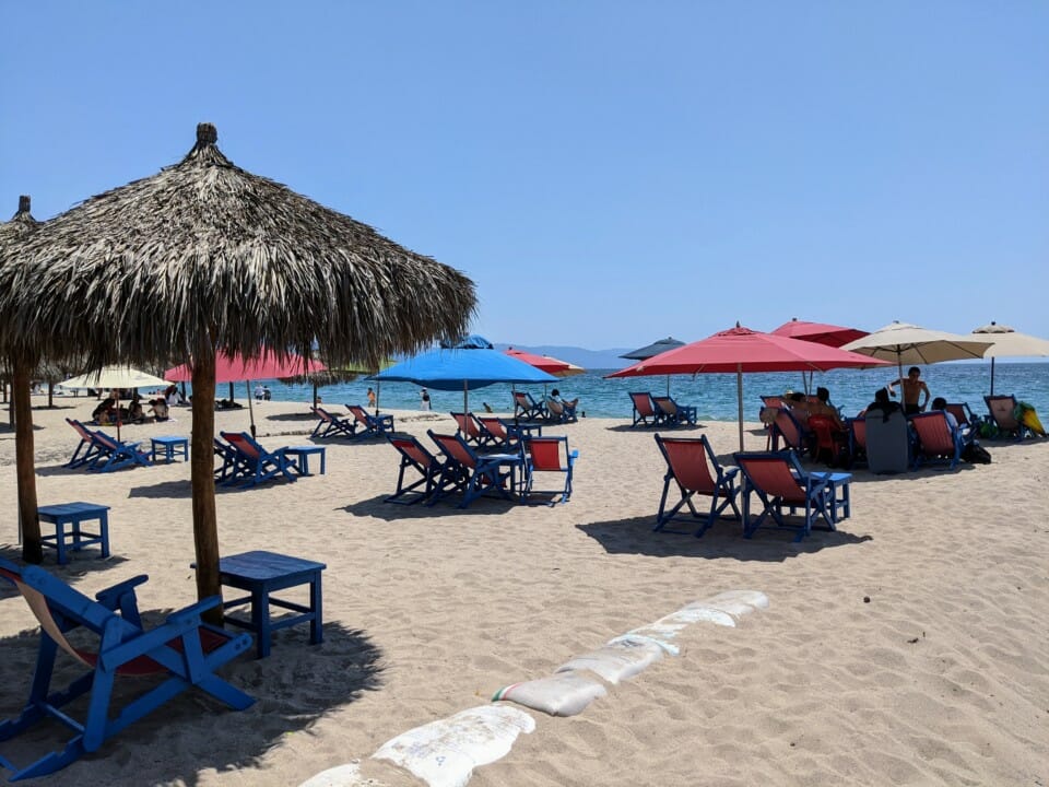 a beach with umbrellas and chairs