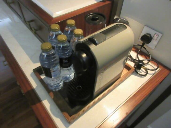 a coffee machine with water bottles on a table