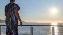 a man standing on a deck overlooking the ocean