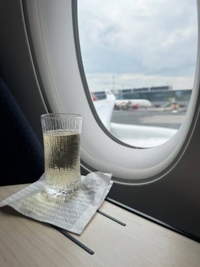 a glass of liquid on a napkin on a table next to a window