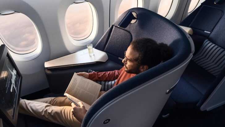 a man reading a book in an airplane