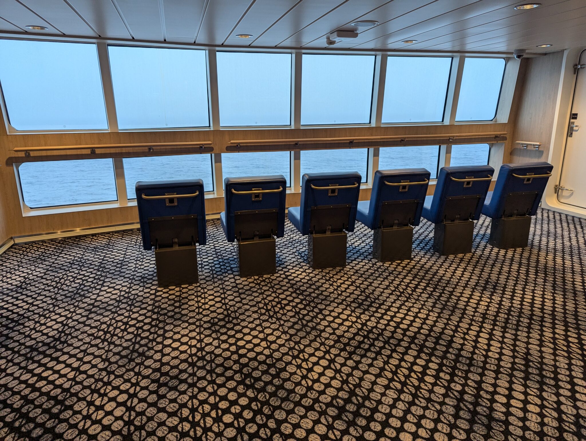 a row of chairs in a room with windows