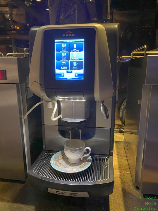 a coffee machine with a screen and a cup on a saucer