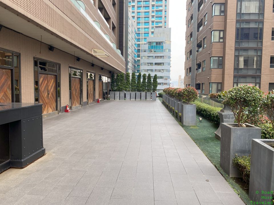 a walkway with plants and bushes in front of a building