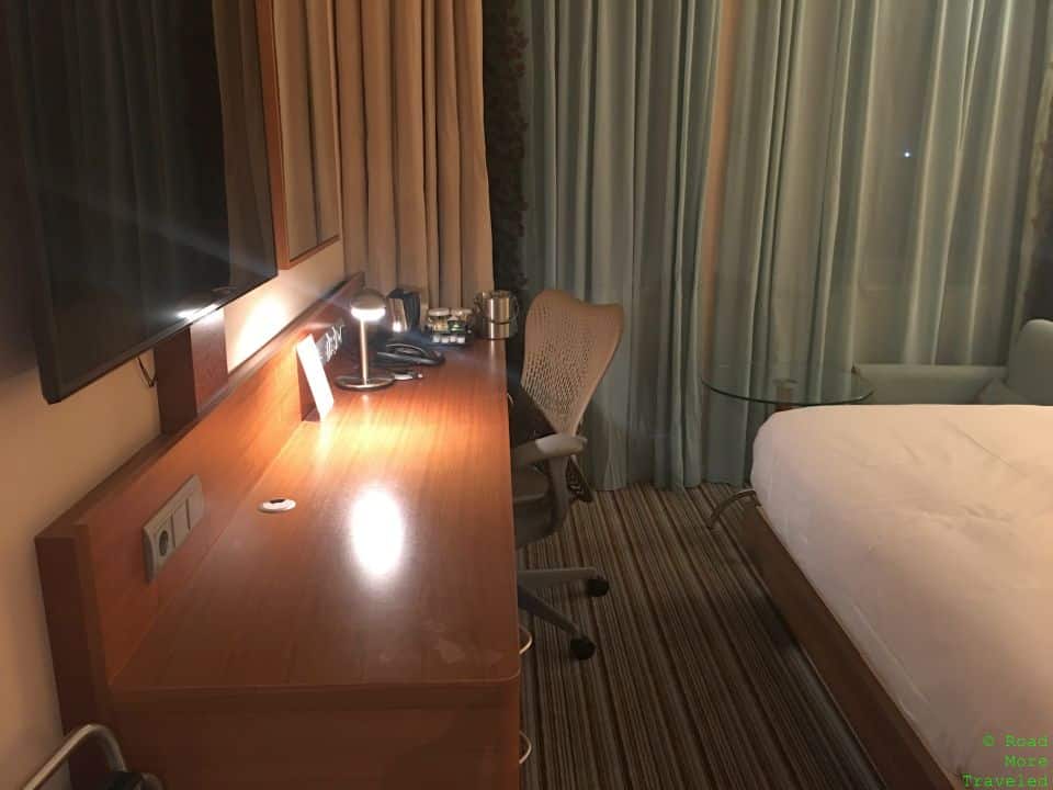 a desk with a tv and a chair in a hotel room