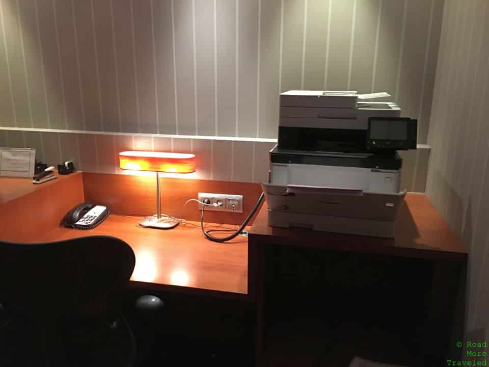 a desk with a printer and a lamp