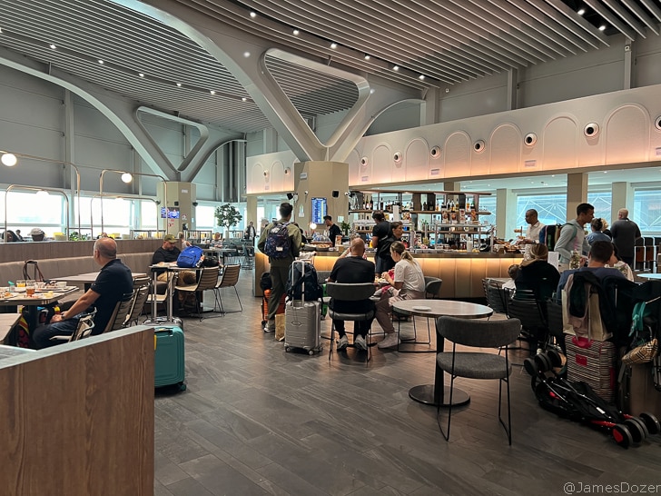 people sitting at tables in a room with luggage