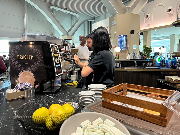 a man standing behind a counter with a coffee machine