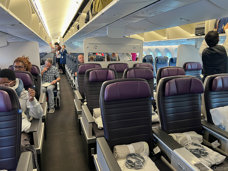 a group of people sitting in chairs on an airplane