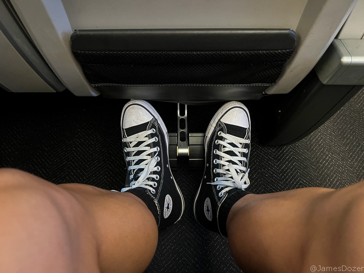 a person's legs in black sneakers