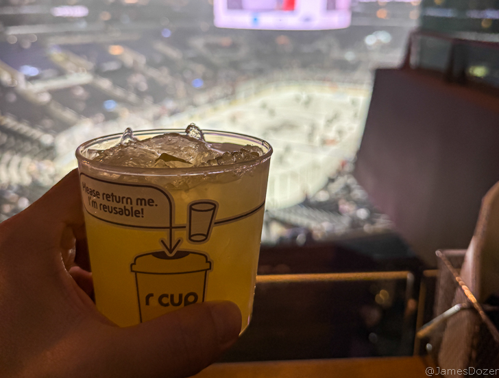 a hand holding a cup of liquid with ice