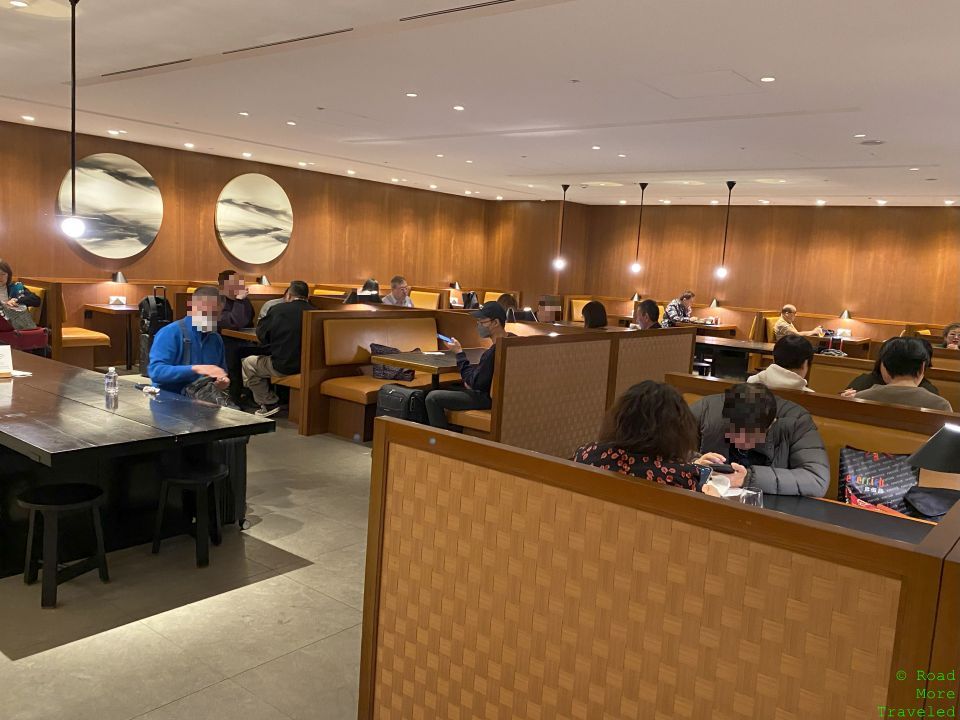 a group of people sitting at tables in a room with wood walls