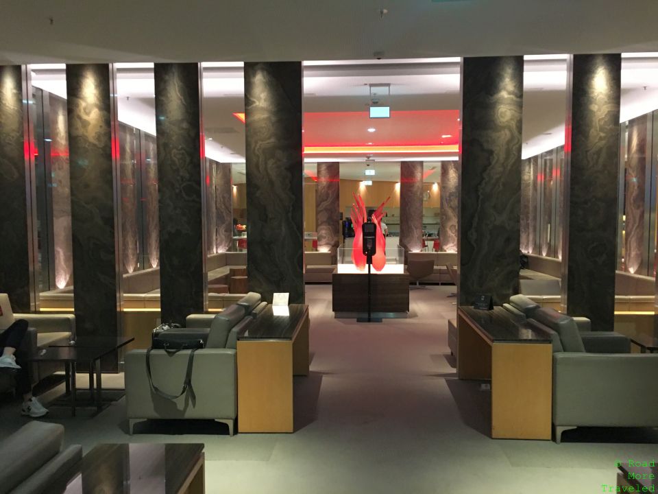 a room with a large stone wall and chairs