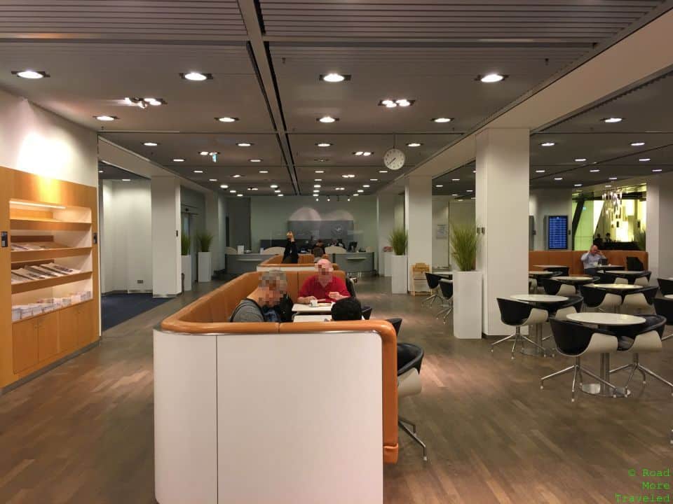 people sitting in a room with tables and chairs