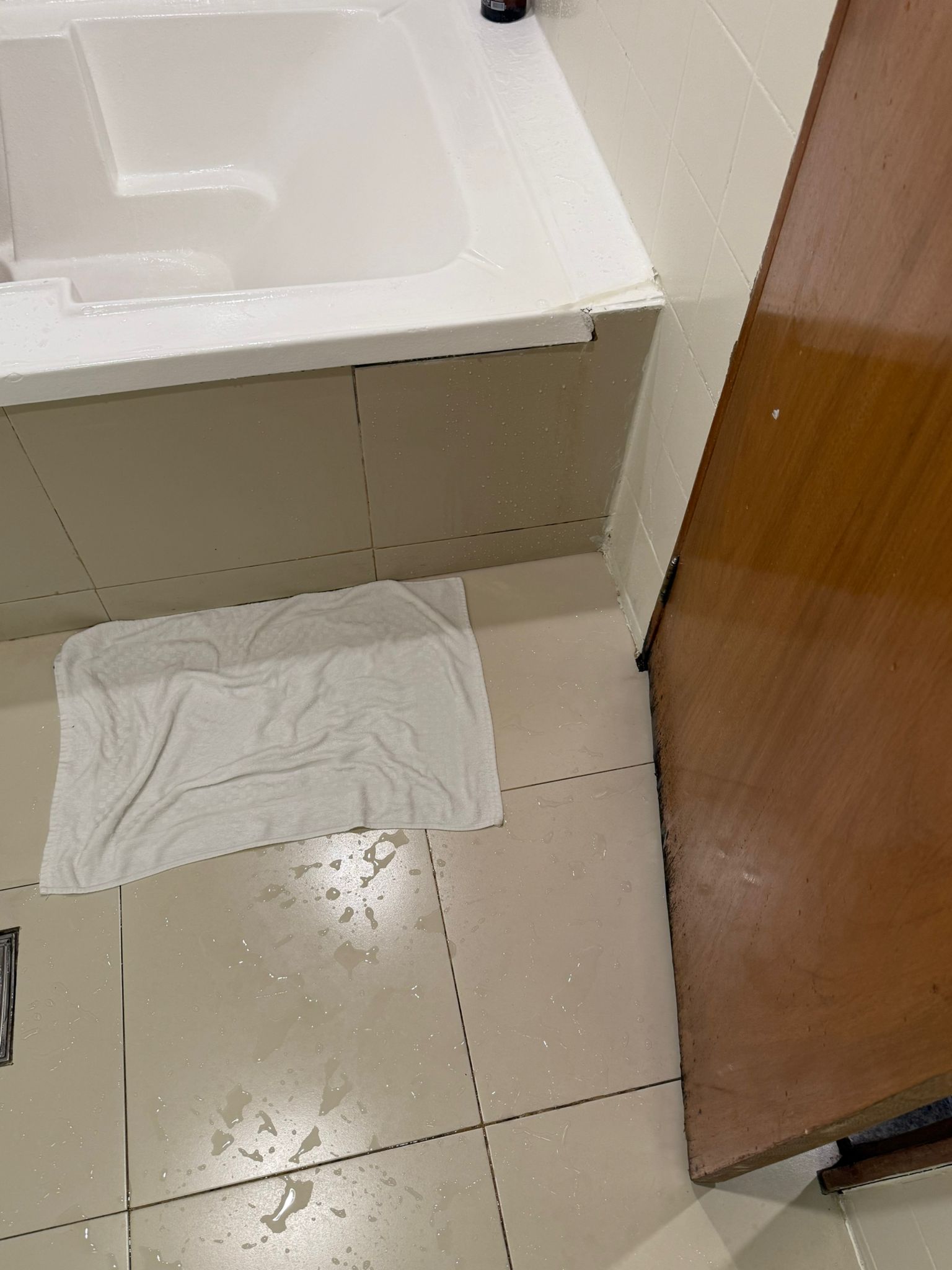 a white towel on the floor of a bathroom