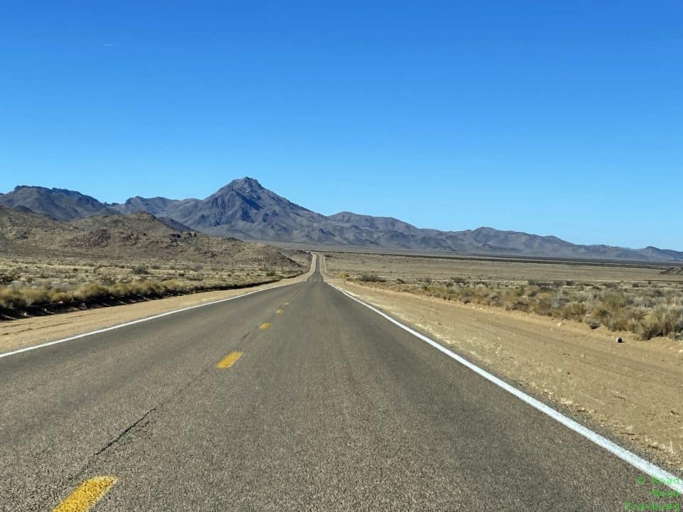 a road with mountains in the background